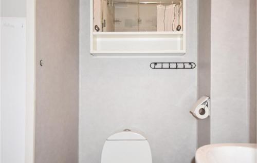 a bathroom with a toilet and a sink and a mirror at Klitterbyn 16 in Ängelholm