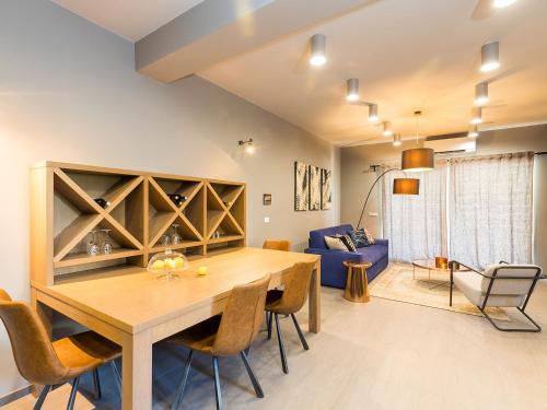 a dining room and living room with a wooden table and chairs at Magnolia - Modern Apartment near City Center and Sea in Poreč