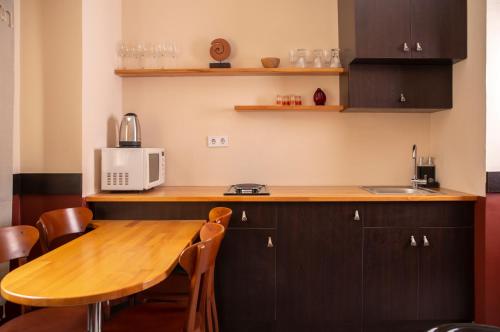 a kitchen with a wooden table and a microwave at LUWİ ANTAKYA BOUTİQUE HOTEL in Hatay