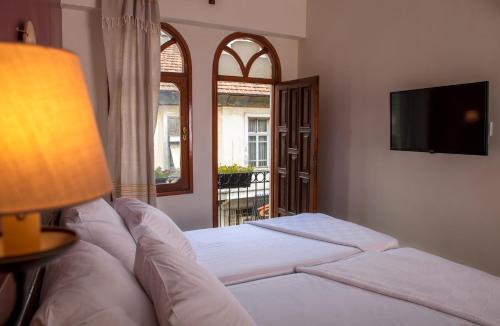 a bedroom with a bed with a television and a window at LUWİ ANTAKYA BOUTİQUE HOTEL in Hatay