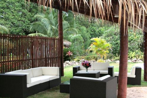 a patio with couches and tables and a fence at Las Puertas del Paraíso in Río San Juan