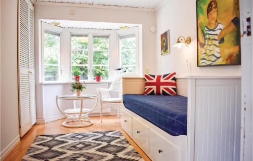 a bedroom with a bed and a table and windows at 3 Bedroom Cozy Home In Frjestaden in Färjestaden