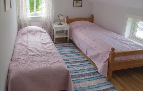 a bedroom with two twin beds and a table at Beautiful Home In Gnosj With 4 Bedrooms in Gnosjö
