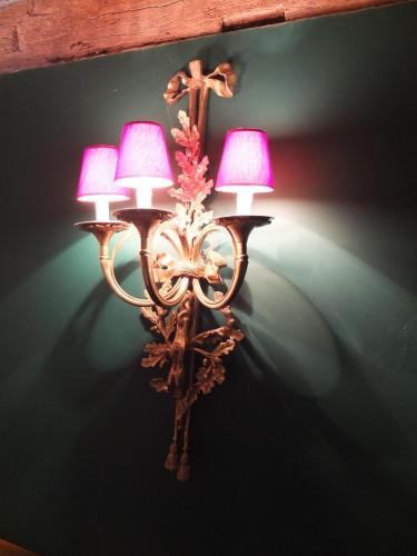 a wall light with two lamps on a wall at Les Confidences de Messire Sanglier, stylished guest houses in Beauraing