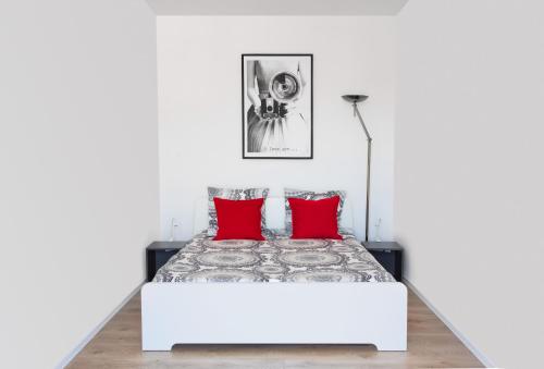 - une chambre blanche avec un lit et des oreillers rouges dans l'établissement LA MAISON DU BONHEUR, à Rouen