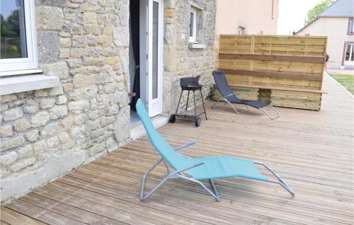 two blue chairs sitting on a deck next to a building at Beautiful Apartment In Sainteny in Sainteny