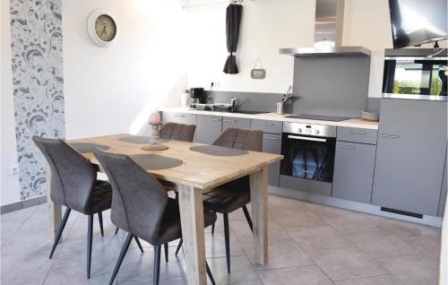a kitchen with a wooden table and chairs at Beautiful Apartment In Sainteny in Sainteny
