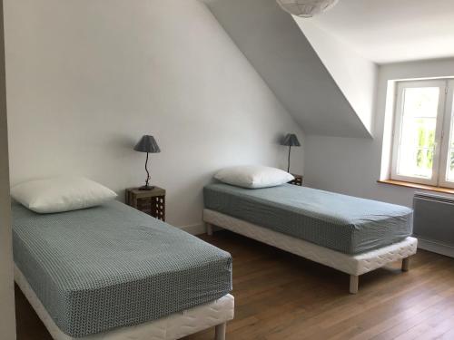 a bedroom with two beds and a window at La vallée des pierres in Saint-Romain-sur-Cher