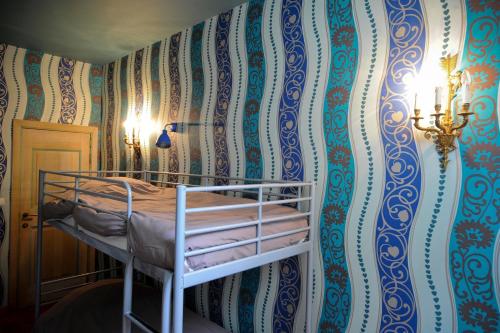 a bedroom with a bunk bed against a colorful wall at Les Confidences de Messire Sanglier, stylished guest houses in Beauraing
