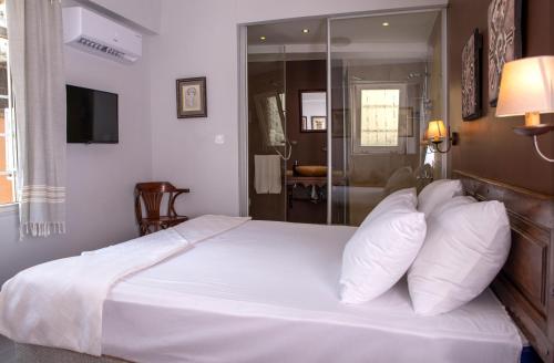 a bedroom with a large bed with white sheets and pillows at LUWİ ANTAKYA BOUTİQUE HOTEL in Hatay