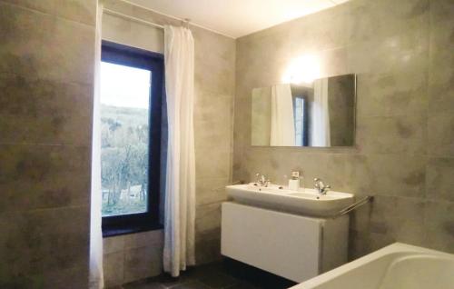 łazienka z umywalką, wanną i oknem w obiekcie Nice Home In Comblinay With Kitchen w mieście Comblinay