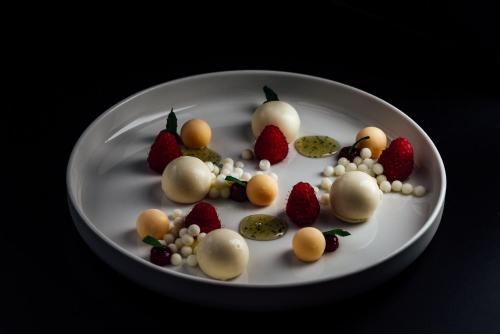 a white plate with strawberries and fruit on it at Hotel-Restaurant Bellevue in Flims