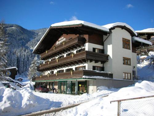 a large building in the snow with snow around it at Pension Margarete in Zell am See