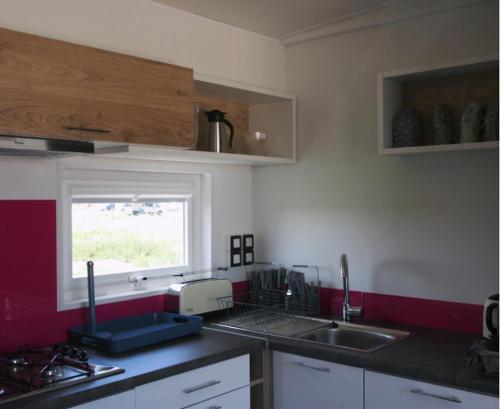a kitchen with a sink and a window at Camping Les Bois Flottés in Salin-de-Giraud