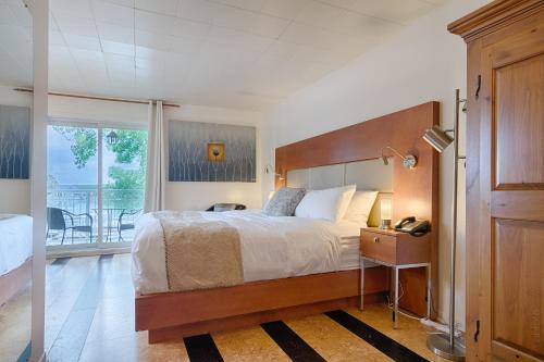 a bedroom with a large bed and a balcony at Auberge Handfield et Spa in Saint-Marc-sur-Richelieu