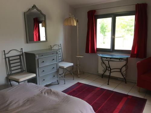 - une chambre avec un lit, un bureau et un miroir dans l'établissement La Meyssonnié, à Damiatte