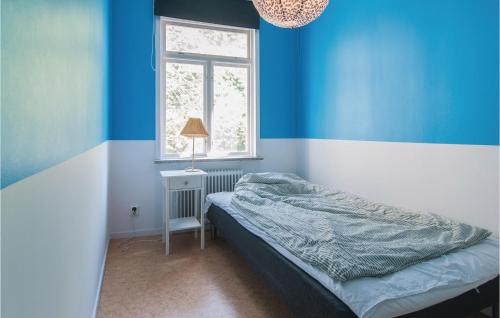 a blue room with a bed and a window at Awesome Apartment In Visby With 3 Bedrooms And Wifi in Visby