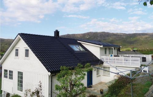 a white house with a black roof at Cozy Apartment In Fitjar in Fitjar
