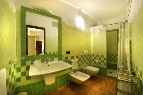 a green tiled bathroom with a sink and a toilet at Il Gallo di Gallura in Tempio Pausania