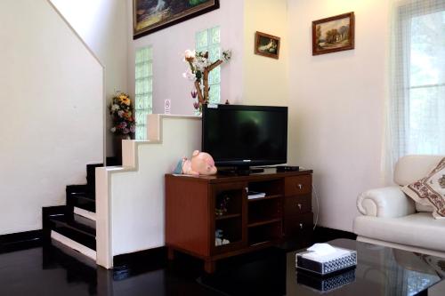 a living room with a tv on a dresser at Moosiyard Hometel Khaoyai in Mu Si