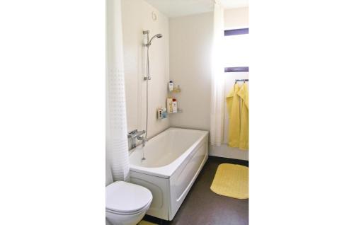 uma casa de banho com uma banheira, um WC e um lavatório. em Nice Apartment In Paulistrm With Kitchen em Pauliström