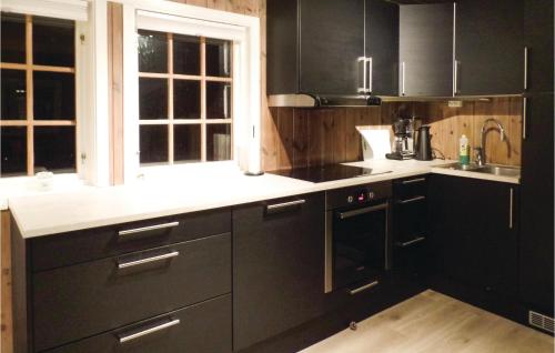 a kitchen with black cabinets and white counter tops at Gorgeous Home In Hovden With House A Mountain View in Hovden