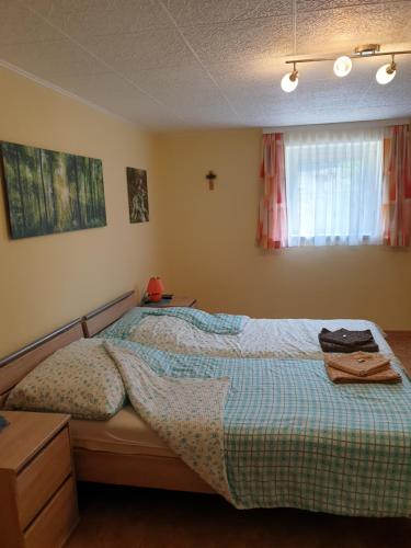 a bedroom with a bed with a blue comforter at Apartment Robert in Maiersdorf