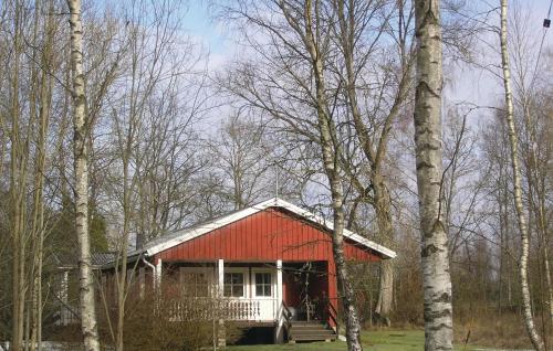 a red cabin with a red roof in the woods at Holiday Home Agunnaryd With Fireplace Vii in Agunnaryd