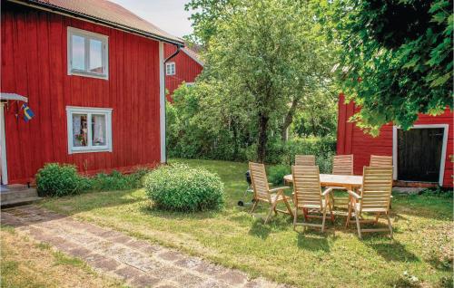a table and chairs in front of a red barn at 3 Bedroom Lovely Home In Vimmerby in Vimmerby