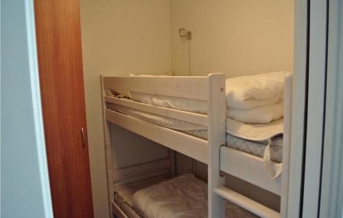 Etagenbett in einem Zimmer mit einigen weißen Betten in der Unterkunft Korshavn Ferieleilighet Nr 203 in Korshamn