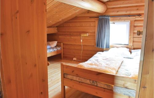 ein Schlafzimmer mit einem Bett in einem Blockhaus in der Unterkunft Cozy Apartment In Trysil With Sauna in Trysil