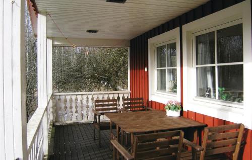 a porch with a wooden table and chairs on a house at Holiday Home Agunnaryd With Fireplace Vii in Agunnaryd
