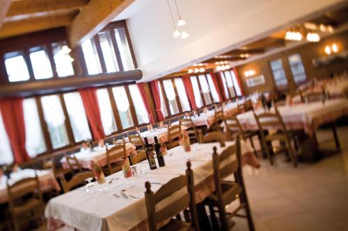 a dining room with tables and chairs with wine bottles at GH Hotel Fratazza in San Martino di Castrozza