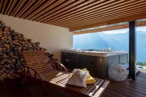 a room with a bench and a tub and a deck at Berghotel Chäserstatt in Ernen
