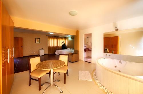 uma casa de banho com uma mesa e uma banheira num quarto em Chappada Hotel em Alto Paraíso de Goiás