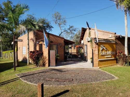 a building with a flag in front of it at Cabañas Solar del Paso in Paso de la Patria