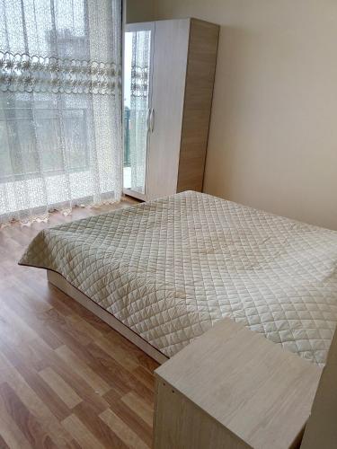 a bedroom with a bed and a large window at Iberia 2019 in Batumi