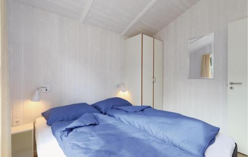 a bed with blue pillows in a white bedroom at Frische Brise 4 - Dorf 3 in Priwall