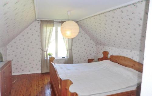 ein Schlafzimmer mit einem Holzbett und einem Fenster in der Unterkunft Beautiful Home In Holmsj With 3 Bedrooms in Holmsjö