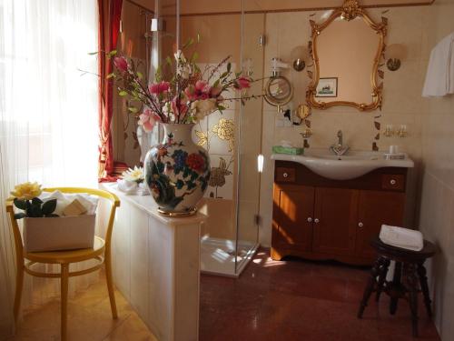 a bathroom with a vase with flowers on a counter at Boutique Hotel Ur-Wachau in Weissenkirchen in der Wachau