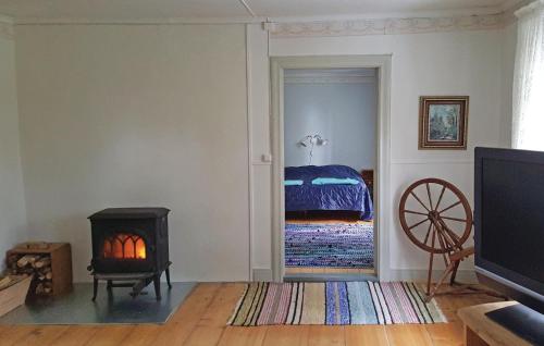 a room with a bedroom with a bed and a fireplace at Awesome Home In Falkping With Kitchen in Broddetorp