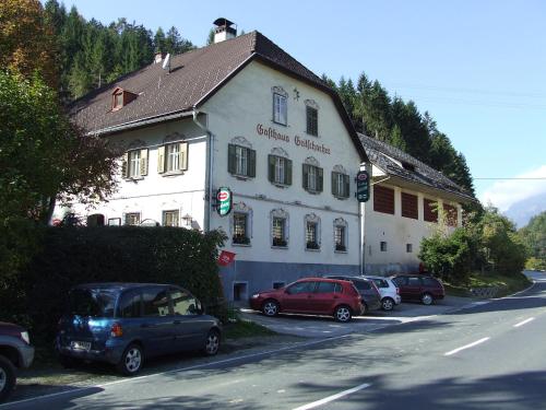 ein weißes Gebäude mit davor geparkt in der Unterkunft Landhaus Gritschacher in Sankt Peter in Holz