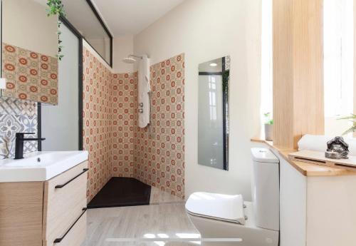 La salle de bains est pourvue d'un lavabo blanc et de toilettes. dans l'établissement Boutike Wellness Centro Almería, à Almería