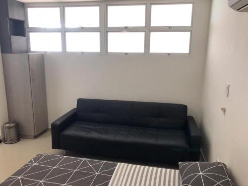 サンタ・マルタにあるEDIFICIO PALANOA APTO 507PQ RODADEROの窓付きの客室で、黒いソファが備わります。