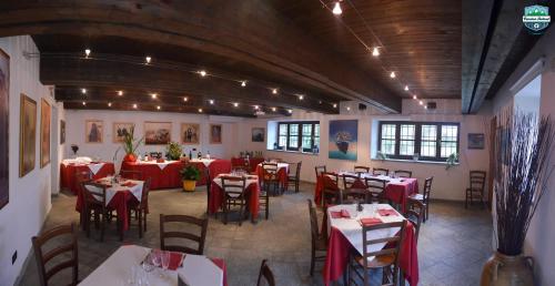 a restaurant with tables and chairs with red table cloth at Cascina Roland in Villar Focchiardo