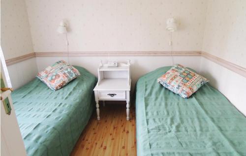 ユングビューにあるAmazing home in Ljungby with 1 Bedrooms and Saunaのナイトスタンド付きの客室で、ツインベッド2台が備わります。