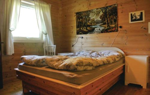 トベーデストランにあるLovely Home In Tvedestrand With House Sea Viewの窓付きの木製の部屋の大型ベッド1台