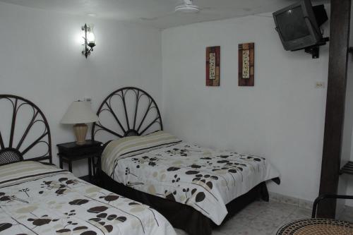 duas camas sentadas uma ao lado da outra num quarto em Hotel Posada del Angel em Mérida