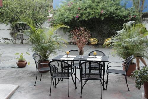 a black table and chairs with plants on a patio at Hotel Posada del Angel in Mérida