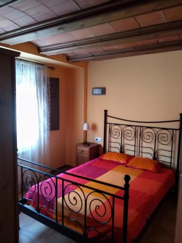 a bedroom with a bed with red sheets and a window at APARTAMENTOS MATARRANYA in Valderrobres